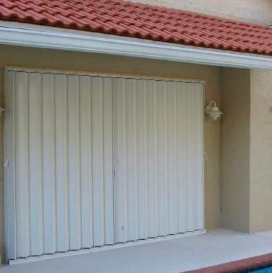 Accordion shutters over sliding glass doors on pool deck