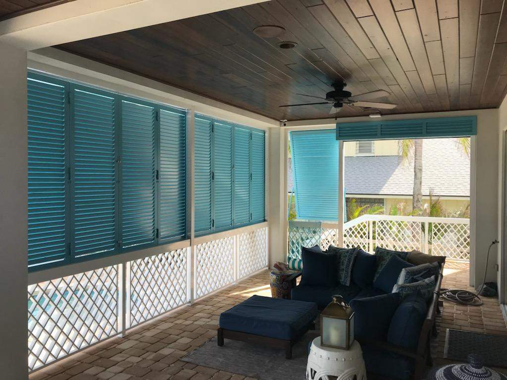 Closed aqua blue colonial shutters on back porch