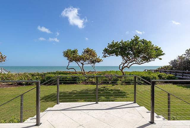 custom brown railing along steps leaning into lush green yard