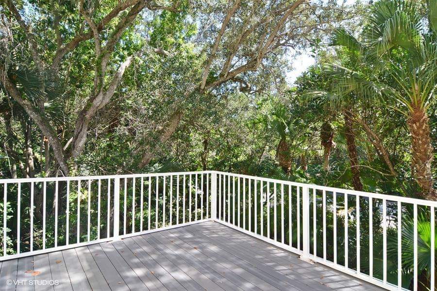 custom white railing surrounding paved deck