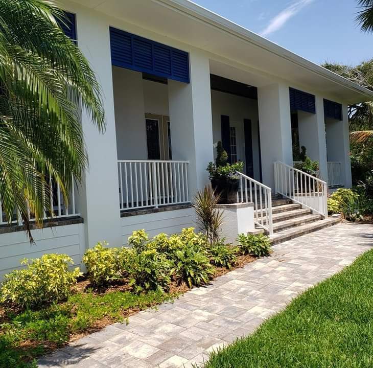 Custom railing on white house with blue roll down shutters