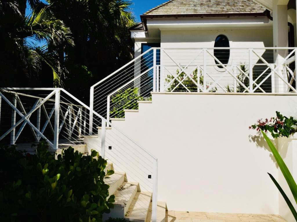 white custom railing along steps lined by shrubs