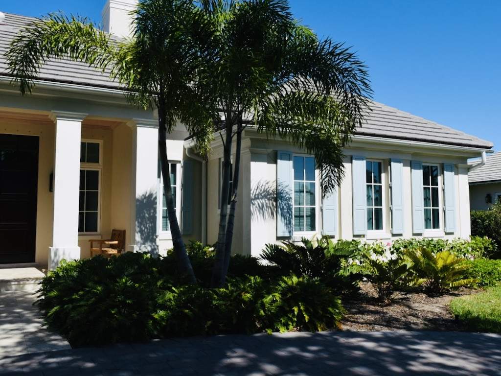 Light blue colonial shutters on an off white house