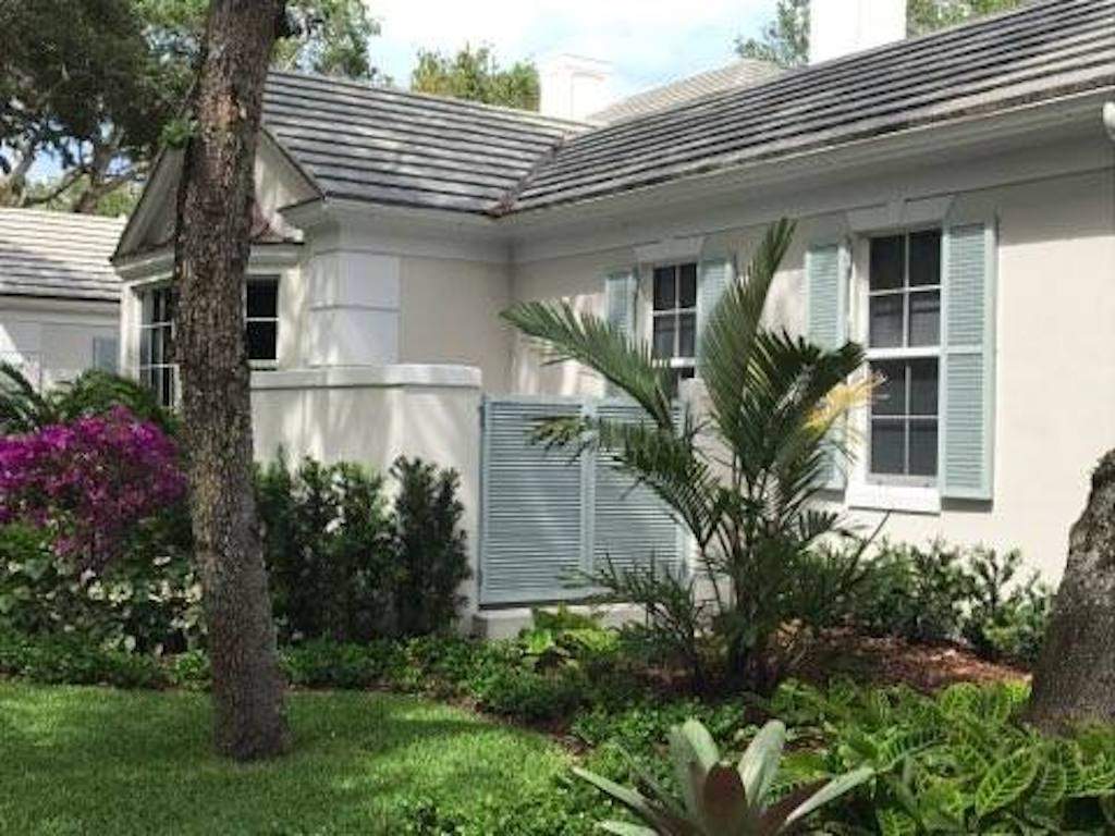 Sage green colonial shutters on off white house