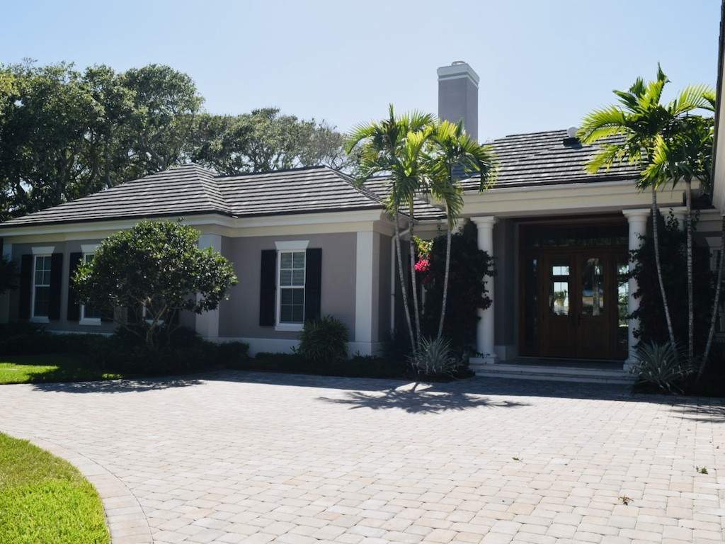 black colonial shutters on dark gray house with large paved driveway