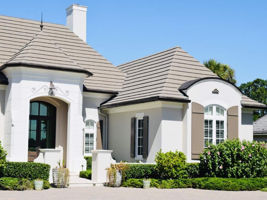 brown colonial shutters with round tops on an off white house