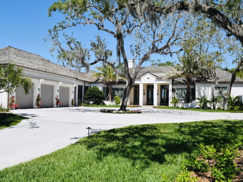 off white house with brown custom garage doors