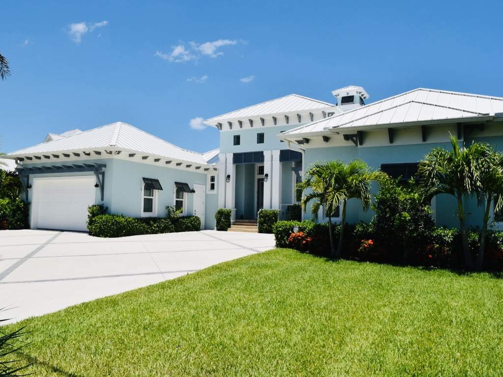 dark bahama shutters on a light blue house with white trim