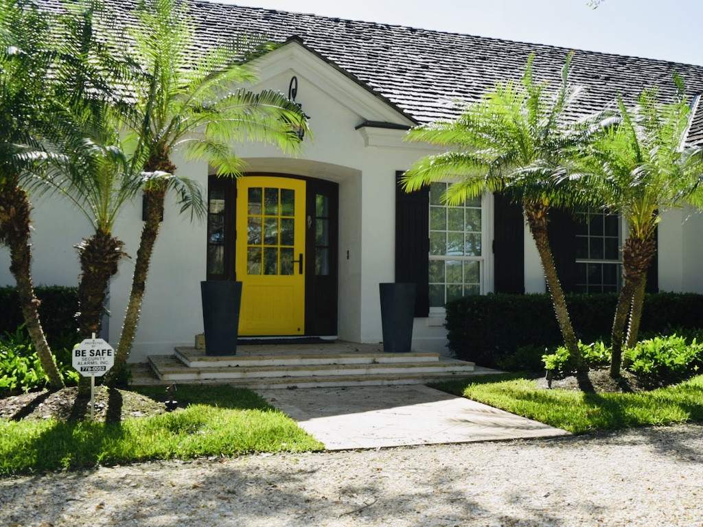 house with black colonial shutters and a yellow door