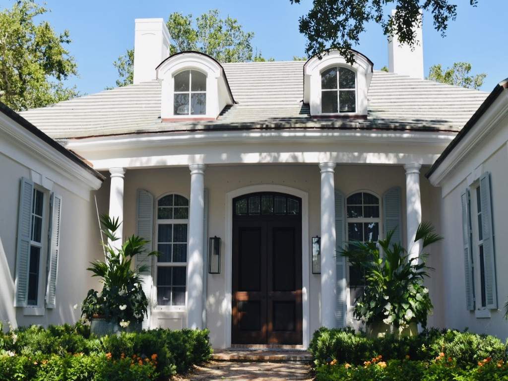 sage green colonial shutters on an off white house with tall white columns on the porch